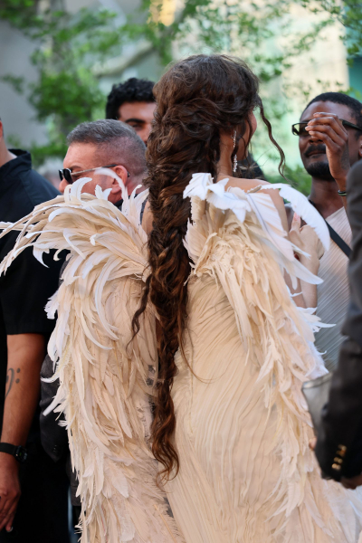 Zendaya wears a feathered gown and a long fishtail braid.
